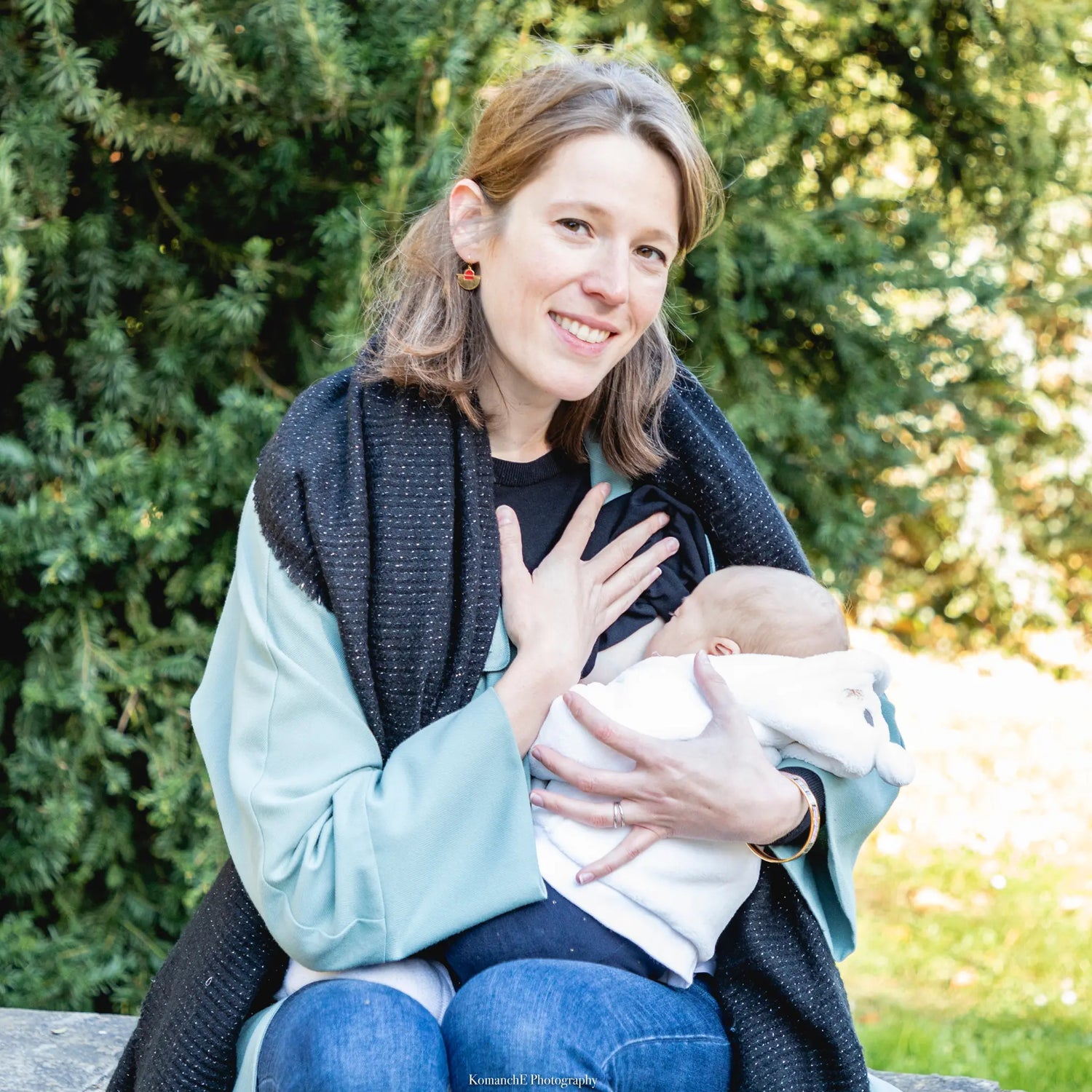 maman souriante allaitant bébé au parc